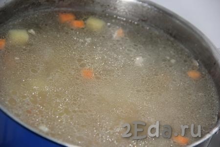 Нарезанные картошку и морковку выложить в кипящий бульон и варить 10-15 минут с момента закипания на небольшом огне.