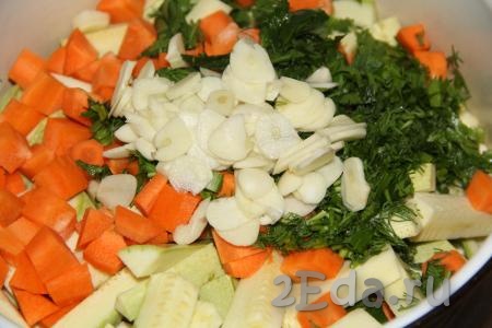 Очищенный чеснок нарезать на тонкие лепестки и добавить к кабачкам, моркови и зелени.