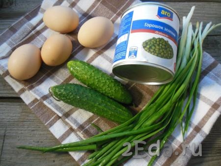 Подготовьте продукты для приготовления салата из огурцов, яиц и зеленого горошка.