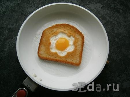 Жарить хлеб с яйцом до тех пор, пока белок не свернется (минуты 3).