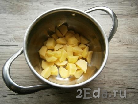 Очищенную картошку, нарезанную кубиками, выложить в кастрюлю.