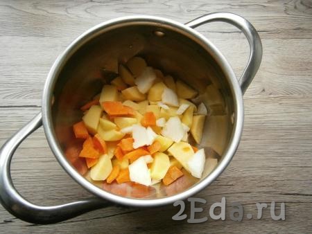Очищенные лук и морковь нарезать произвольно и тоже выложить в кастрюлю.