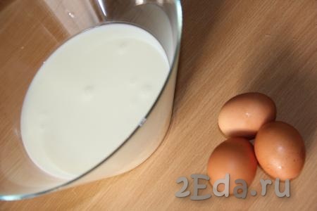 Кислое молоко влить в глубокую миску, добавить яйца и перемешать венчиком.