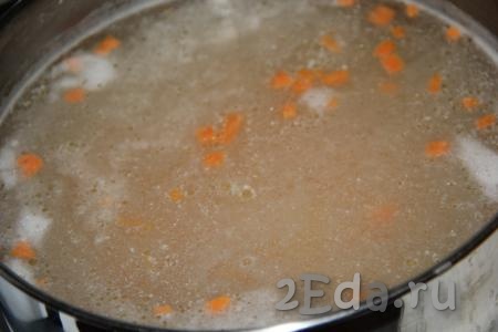 Нарезанные мясо, картофель и морковь выложить в кипящий куриный бульон, уменьшить огонь и варить суп 15-20 минут.