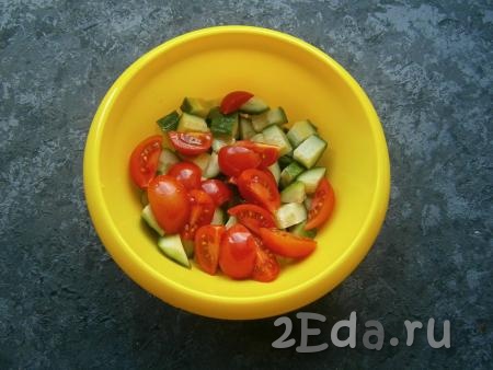 К огурцам, нарезанным средними кубиками, выложить помидоры черри, нарезанные на 2-4 части.