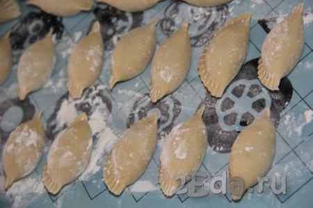Сформированные пельмени выложить на припорошенную мукой поверхность. Можно выложить пельмешки в один слой на доску и заморозить их в морозилке впрок, а можно сразу отварить их и подать к столу.