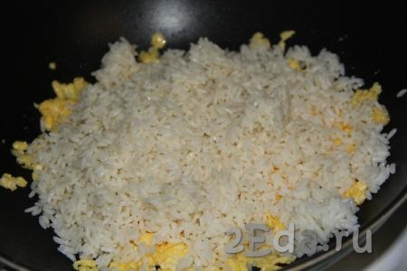 Затем добавить вареный рис в сковороду с жареными яйцами.