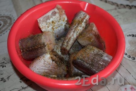 Далее складываем в миску кусочки хека, солим, перчим и посыпаем рыбу специями по вкусу (у меня специи для рыбы).
