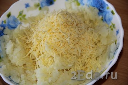 Сыр натереть на мелкой тёрке. Добавить сыр к толчёной картошке и перемешать.