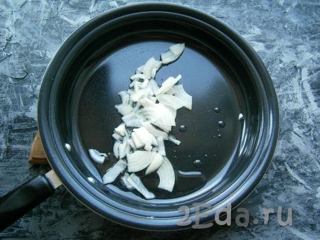 Нарезать произвольно очищенный репчатый лук, выложить его на сковороду, влить растительное масло.