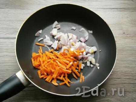 Лук нарезать кусочками, морковь - соломкой и поместить в сковороду, влить растительное масло.