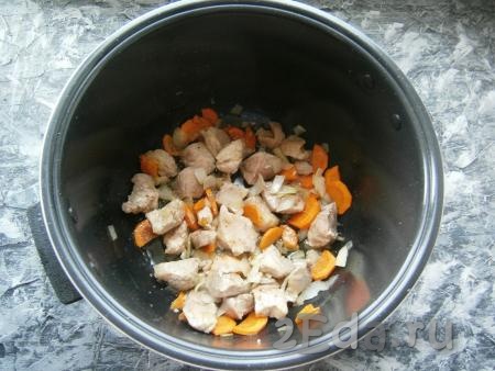 Посыпать мясо немного специями и обжаривать, помешивая, 10 минут. Далее добавить морковку с луком, перемешать и готовить еще 10 минут, периодически перемешивая.