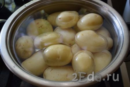 Кипятим воду в чайнике. Далее очищенную молодую картошку кладем в кастрюлю для варки и полностью заливаем кипятком.