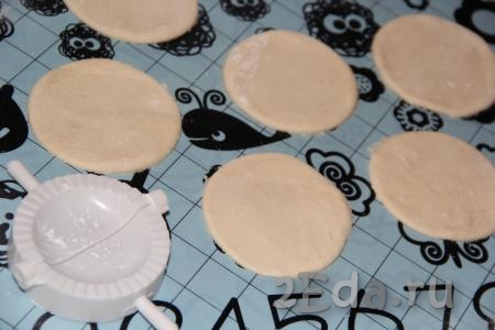 На припыленном мукой столе (или на силиконовом коврике) скалкой тонко раскатать тесто и вырезать стаканом кружочки. Вареники можно слепить, как обычно, руками, я решила сформировать вареники с помощью формочки.