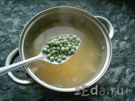 В куриный суп выложить замороженный зеленый горошек, дать закипеть.