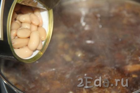 Добавить лук с крупой и фасоль (консервированную или предварительно сваренную до готовности) в кастрюлю с грибами. Варить грибной суп в течение 10 минут. Затем посолить супчик по вкусу, накрыть крышкой, снять с огня и дать настояться в течение 20 минут.