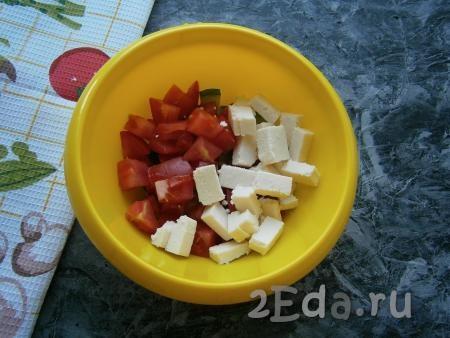 Свежий помидор и адыгейский сыр нарезать кубиками и выложить к огурцам.