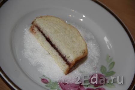 В плоскую тарелку насыпать сахар. Обмакнуть получившийся маленький бутерброд масляной стороной в сахар и выложить на противень сахаром вверх.