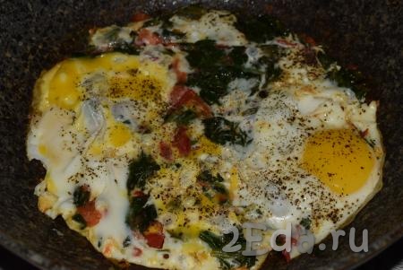Затем к обжаренным помидорам и шпинату вбиваем яйца, слегка солим и перчим. Готовим яичницу на небольшом огне 2-3 минуты (белок должен полностью свернуться, а желток - остаться жидким).