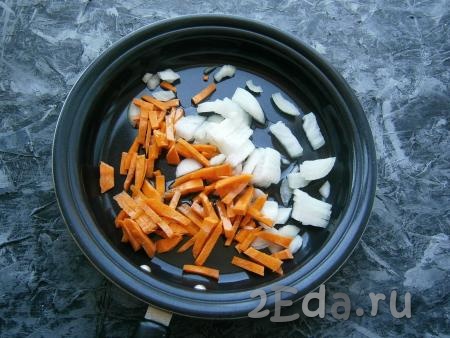 В сковороду с растительным маслом выложить лук, нарезанный небольшими кусочками, и морковку, нарезанную брусочками (или соломкой).