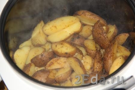 Через 20 минут  перемешать картофель, закрыть крышку мультиварки и готовить до сигнала. 