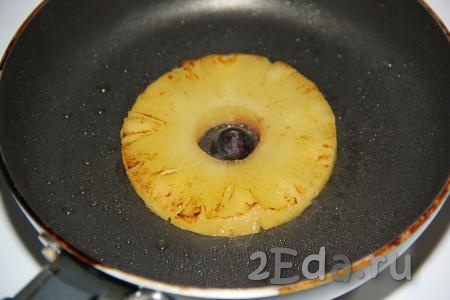 Жарить ананас пару секунд на среднем огне, затем перевернуть и вложить в серединку ананаса ягодку для украшения. Я использовала чёрную смородину, можно заменить на вишню.