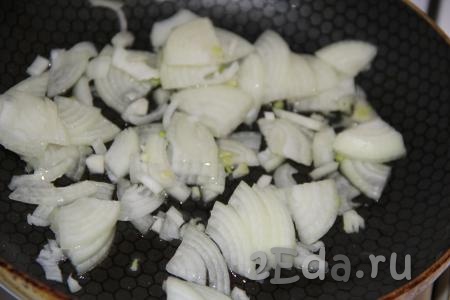 Нарезать тонкими полукольцами очищенный лук, выложить его в сковороду, добавить 1 столовую ложку растительного масла.