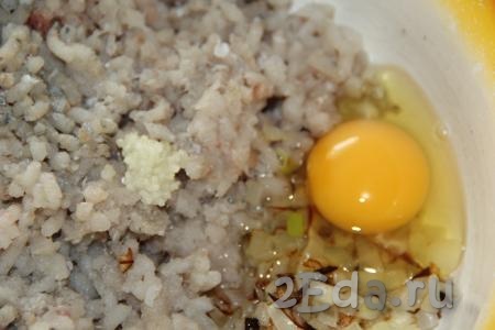 К фаршу и луку добавить яйцо, пропущенный через пресс чеснок, соль и специи.
