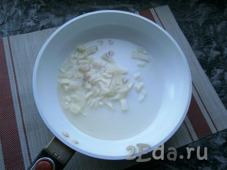 Пока тесто "подходит", нужно приготовить начинку. Для этого в сковороду влить растительное масло, выложить мелко нарезанный очищенный репчатый лук.