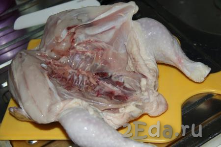 Цыплёнка промыть под проточной водой и обсушить бумажным полотенцем. Разрезать птицу по грудке и развернуть (как на фото).