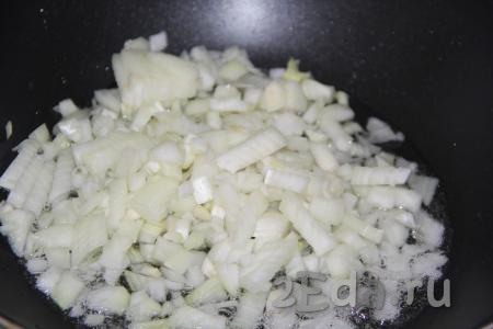 Пока рис пропаривается, приготовить зажарку, для этого сковороду вок (или любую сковороду с высокими бортиками) влить растительное масло, а затем выложить очищенный и мелко нарезанный лук.