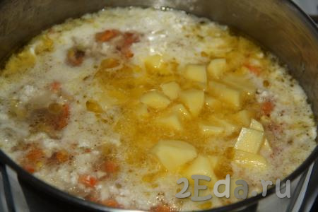 Очищенные клубни картофеля нарезать на средние кубики и выложить в кастрюлю с супом, после закипания уменьшить огонь и варить минут 15.