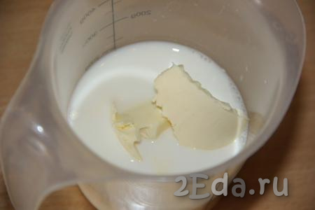 В отдельную ёмкость (я взяла стакан) влить молоко, добавить сливочное масло, нарезанное на кусочки.
