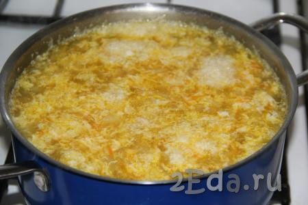 Влить тонкой струйкой яйцо в кипящий суп, интенсивно перемешивая, затем уменьшить огонь и проварить ещё 3-5 минут.