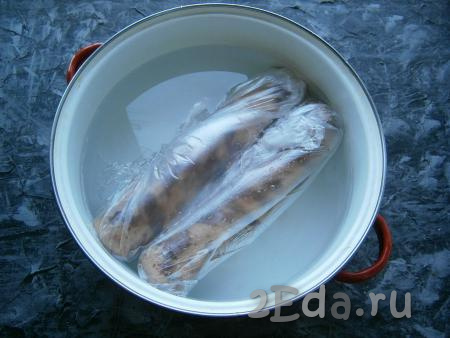 Каждую колбаску поместить дополнительно в целлофановый пакет, который плотно завязать. Также вы можете использовать и рукав для запекания, тщательно зафиксировав края. Поместить колбасу в большую кастрюлю с холодной водой.