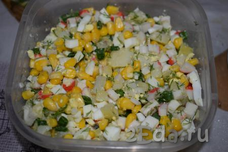К кукурузе добавляем нарезанные картошку, крабовые палочки, зелёный лук, зелень, яйца и перемешиваем.