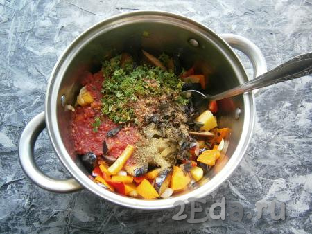 Помидоры прокрутить через мясорубку (или натереть на терке), добавить их к овощам. Сюда же всыпать смесь перцев, хмели-сунели, кориандр, добавить измельченные петрушку и базилик.