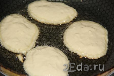В сковороду влить растительное масло, а затем выложить по 1 столовой ложке теста, формируя оладушки.