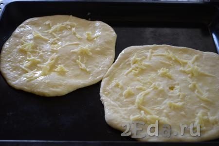 Далее смазываем наши хачапури яйцом, смешанным с молоком, и посыпаем натёртым на крупной тёрке сыром.