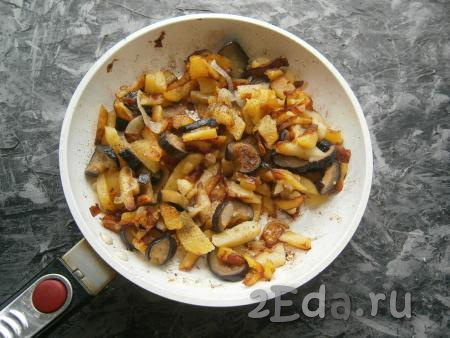 Жарить картошку с баклажанами и луком на небольшом огне под прикрытой крышкой, иногда перемешивая, ещё около 10-15 минут (до готовности баклажанов). В конце приготовления блюдо посолить и поперчить.