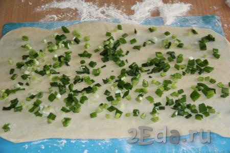Выложить на тесто половину нарезанного зелёного лука.