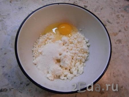 В творог (лучше взять базарный, жирненький) добавить сырое яйцо, щепотку соли, всыпать сахар.