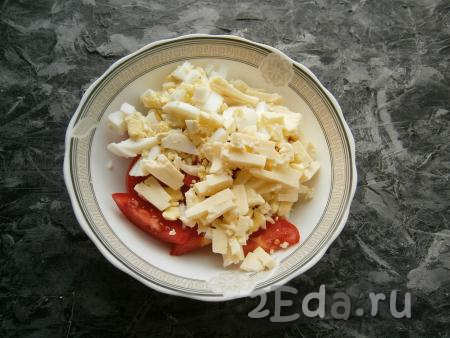 К помидорам добавить нарезанный брусочками сыр и нарезанные длинными кусочками варёные яйца.