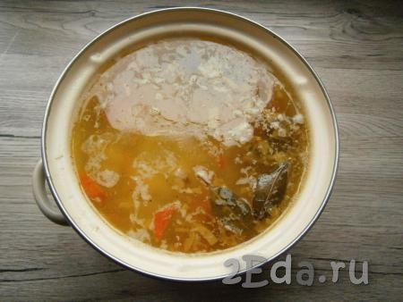Отправить обжаренные овощи в кастрюлю с готовым картофелем и свининой, если нужно, суп досолить. Всыпать приправу, добавить нарезанный чеснок и лавровые листья, варить суп на слабом огне 5-7 минут.