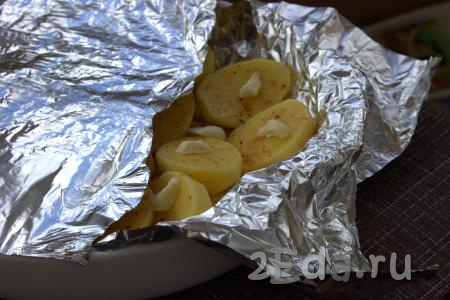 Жаропрочную форму с половинками картофеля, маслом и чесноком плотно накрыть фольгой и отправить в духовку, разогретую до 200 градусов, на 25-30 минут (запекать до аппетитного золотистого цвета картошки). Время запекания зависит от сорта картофеля. Чтобы убедиться, что картофель полностью готов, необходимо проткнуть его зубочисткой. Если картофелина легко прокалывается - значит готова.