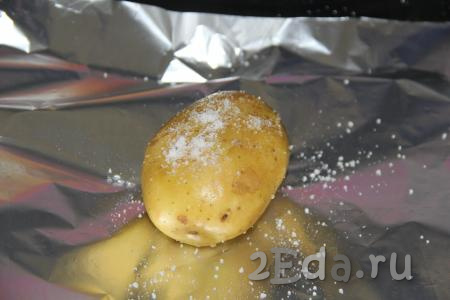 Картофель тщательно вымыть. Одну картофелину выложить на кусок фольги и присыпать щепоткой соли, плотно завернуть в фольгу. Аналогично завернуть в фольгу оставшиеся картошины.