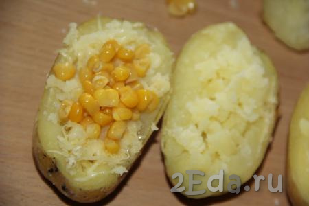 Затем в картофельно-сырную начинку каждой картофельной лодочки добавить по 1 чайной ложке кукурузы.