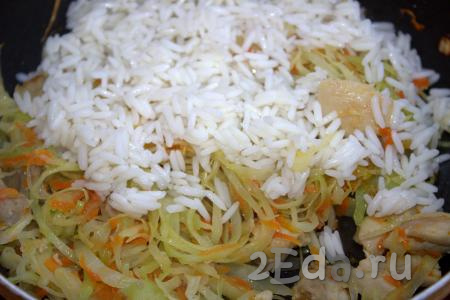 Когда капуста, тушёная с курицей и овощами, будет готова, добавить рис, хорошо перемешать.