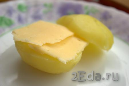 Разрезать каждую картофелину вдоль на две части. Поверх одной половинки картошки положить ломтик сыра, накрыть второй половинкой картошины, слегка посолить и приправить специями по вкусу.