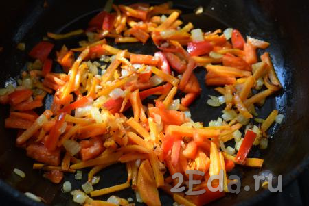 Вторую луковицу очистим и нарежем мелкими кубиками. Оставшуюся половину моркови нарежем соломкой. Болгарский перец очистим от семян и плодоножки, нарежем на полоски. Ставим сковороду на средний огонь, добавляем в неё растительное масло, слегка прогреваем его и кладём нарезанные морковь, болгарский перец и лук. На медленном огне обжариваем овощи, периодически помешивая, до прозрачности (примерно, 8-10 минут) и выключаем огонь.